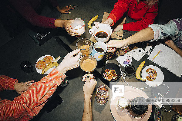Hochwinkelansicht eines Unternehmers  der in einem kreativen Büro Kaffee über einem Tisch röstet
