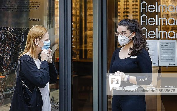 Mandatory mask when shopping in NRW  Fielmann customers are given a mouth-and-nose protection by an employee wearing an FFP2 mask and protective gloves in front of entering the shop  everyday life in times of the Corona Pandemic  Essen  Ruhr Area  Nordrh