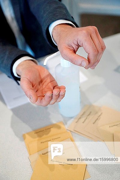 French election during coronavirus (COVID-19) crisis. Hands disinfection. Hands with disinfecting alcohol gel prevent virus epidemic.