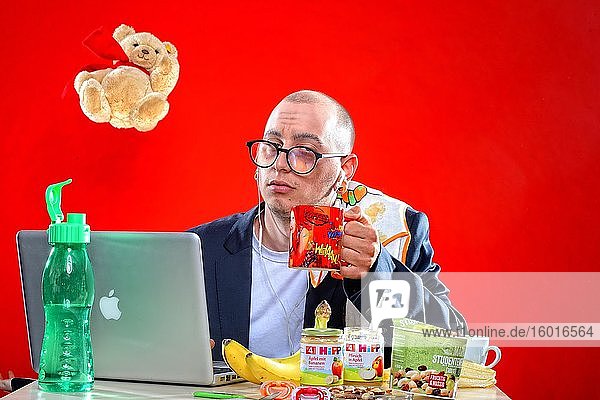 Young man with snacks in front of notebook Corona Series Germany Europe