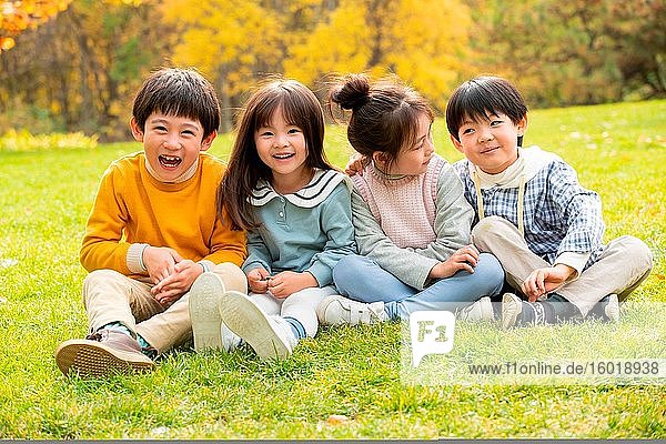 Lovely children sitting on the grass to play