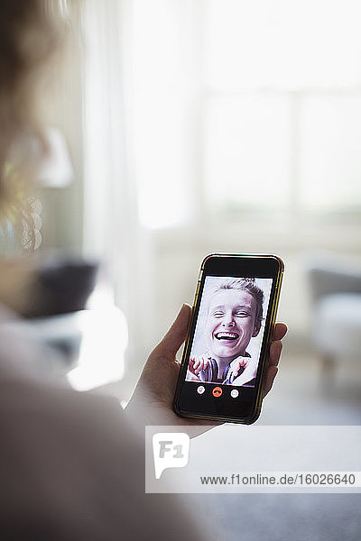 Happy women friends video chatting on smart phone screen