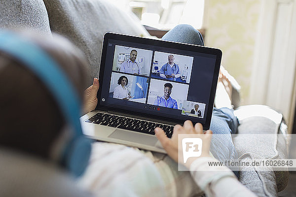 Teenager-Mädchen im Video-Chat mit Ärzten auf Laptop-Bildschirm