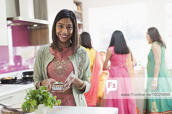 Porträt einer glücklichen indischen Frau in Sari und binden kochendes Essen in der Küche