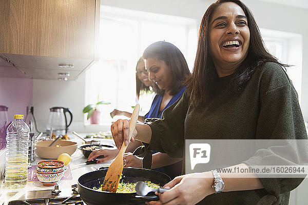 Glückliche indische Frauen kochen Essen in der Küche