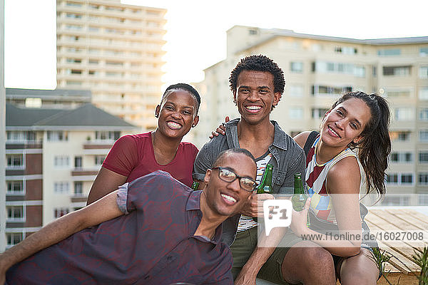 Porträt glücklicher junger Freunde auf dem sonnigen Dach der Stadt