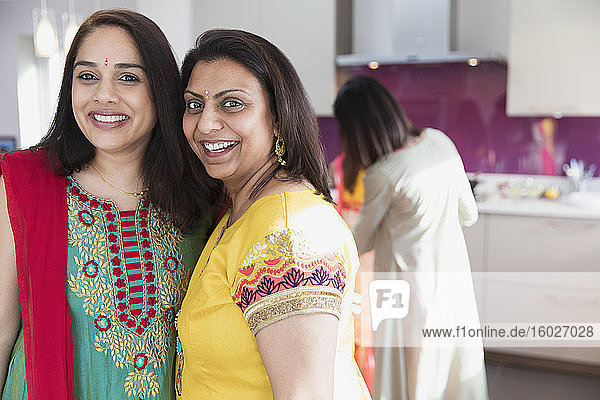 Porträt glücklicher indischer Frauen in Saris in der Küche
