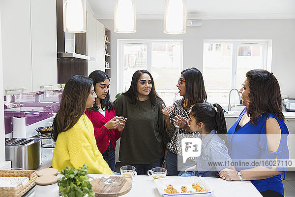 Indische Frauen reden und kochen in der Küche