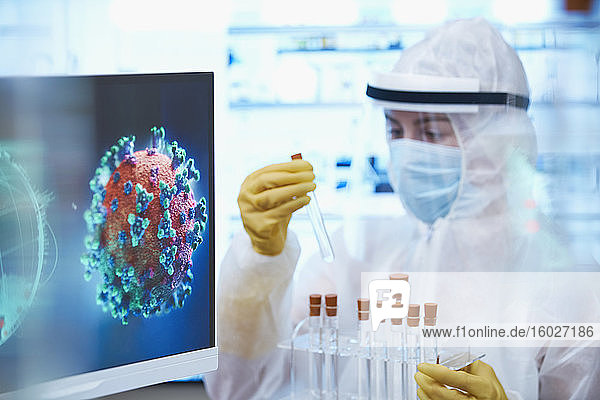 Wissenschaftlerin im Reinraumanzug mit Reagenzgläsern untersucht Coronavirus