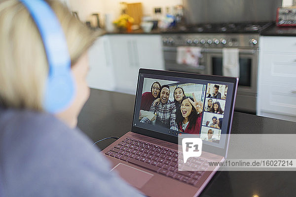 Frau mit Laptop im Video-Chat mit Freunden in der Küche
