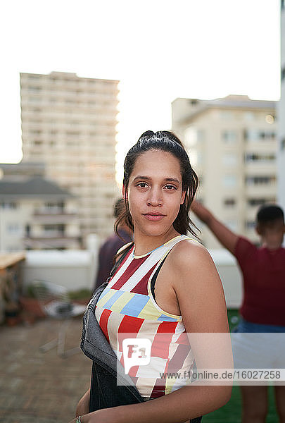 Porträt selbstbewusste junge Frau auf städtischem Dachbalkon
