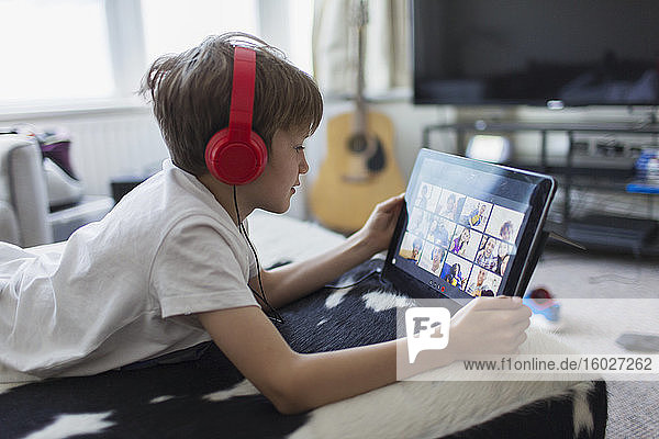 Boy with headphones and digital tablet homeschooling