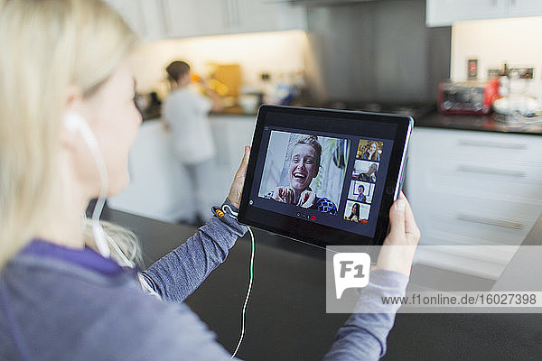 Frau im Video-Chat mit Freunden auf digitalem Tablet