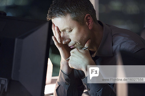 Tired businessman working late at computer