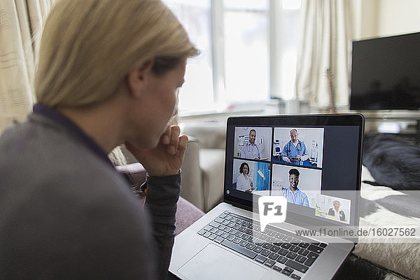Frau im Video-Chat mit Ärzten am Laptop von zu Hause