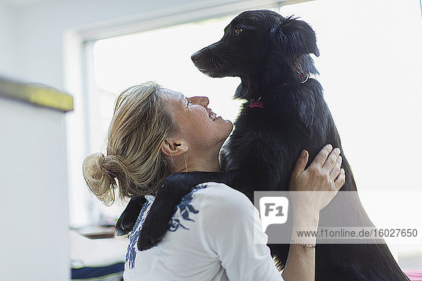 Glückliche Frau umarmt Hund