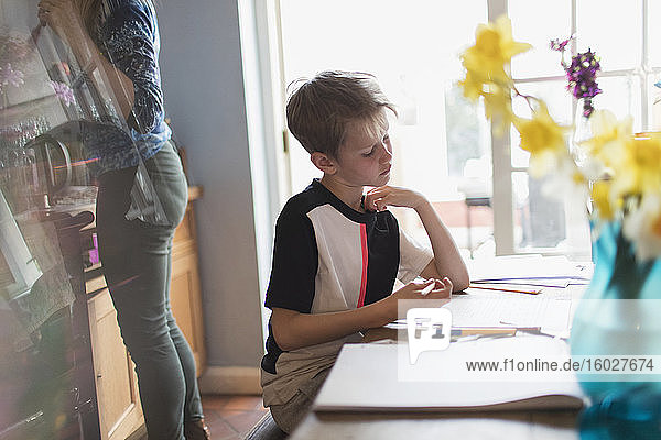 Boy doing homework at kitchen table