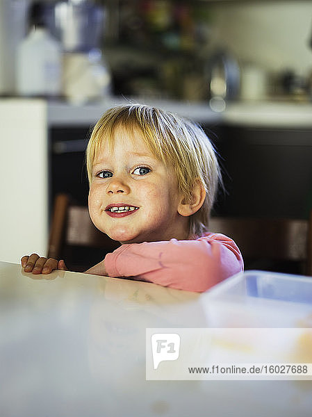 Lächelnder Junge lehnt an Küchentheke