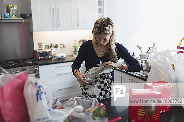 Frau packt Lebensmittel in der Küche aus
