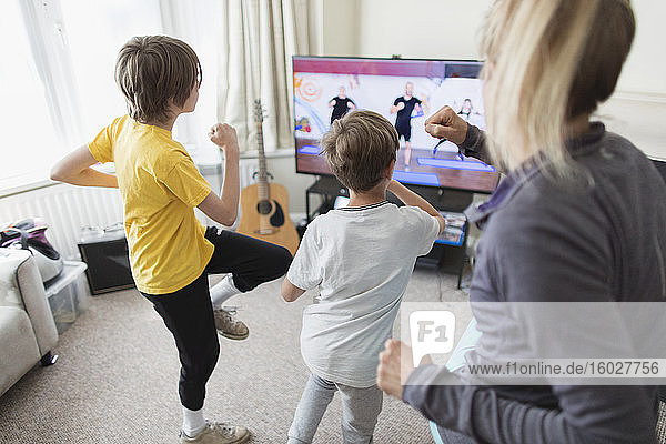 Family exercising at TV in living room