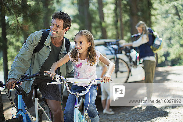 Vater und Tochter auf Fahrrädern im Wald