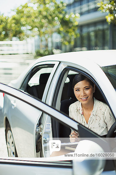 Smiling businesswoman sitting in car