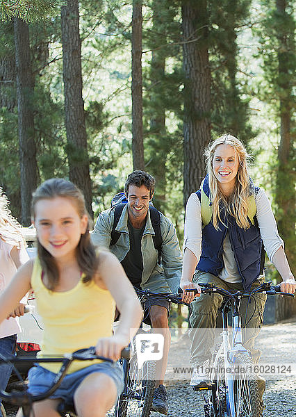 Lächelndes Familienradfahren im Wald