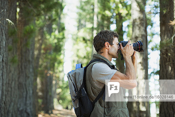 Man using digital camera in woods