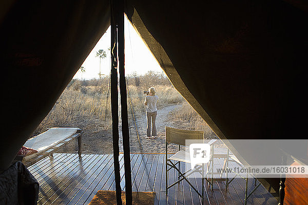 Woman taking a photograph at dusk  in the Kalahari Desert.