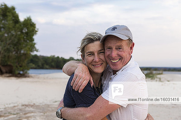 Mature couple embracing o the banks of the Zambezi River.