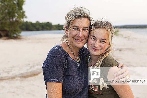Mature woman and a young teenage girl  mother and her daughter on the banks of a wide river.