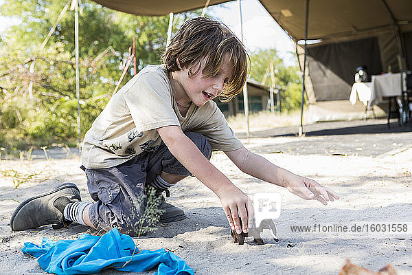 Ein sechsjähriger Junge spielt mit Spielzeug in einem Zeltlager  Nxai Pa  Botswana