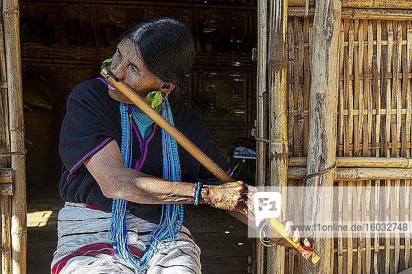 Kinn-Frau mit Spinnennetztattoo  die mit ihrer Nase eine Flöte bläst  Kanpelet  Chin-Staat  Myanmar (Burma)  Asien