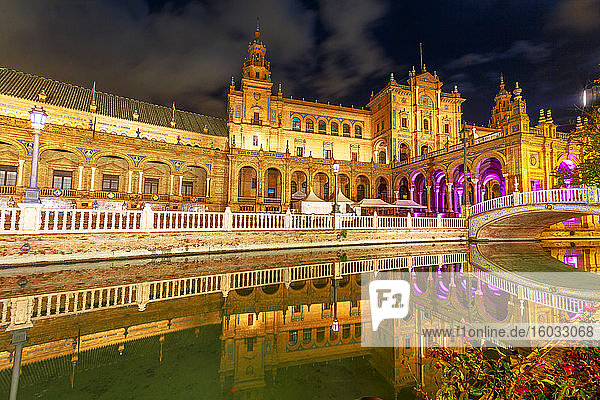 Renaissance-Gebäude auf der Plaza de Espana (Spanien-Platz)  reflektiert auf dem Kanal des Guadalquivir-Flusses  nachts beleuchtet  Sevilla  Andalusien  Spanien  Europa