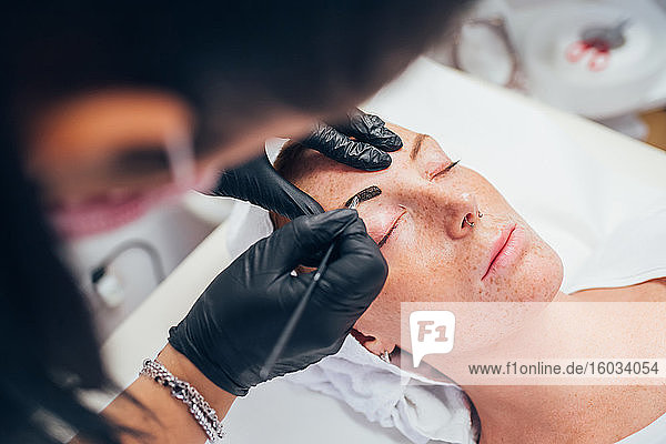 Woman getting her eyebrows done in a beauty salon.
