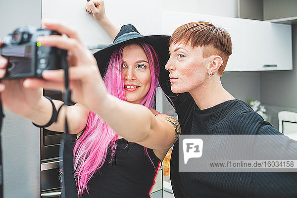 Junge Frau mit langen rosa Haaren und Frau mit kurzen roten Haaren beim Selfie.