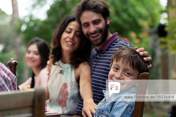 Junge und Eltern beim Familienessen im Freien