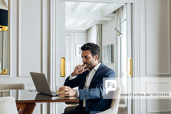 Businessman using laptop in suite