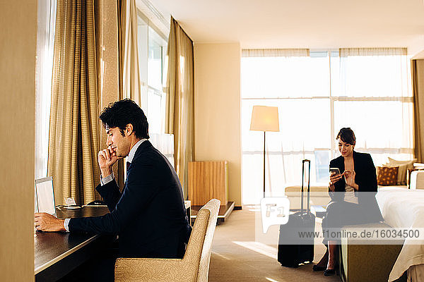 Geschäftsmann und Geschäftsfrau  die im Hotelzimmer arbeiten