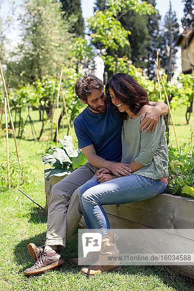Affectionate mid adult couple sitting in garden