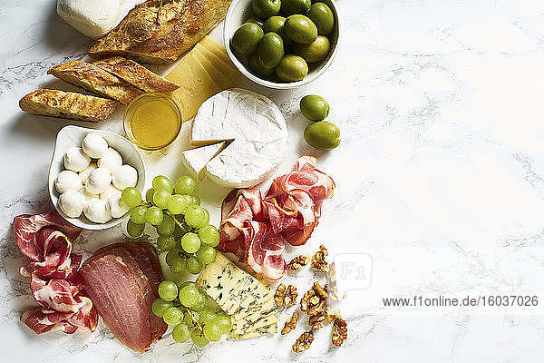 Käse-Schinken-Platte mit Walnüssen  Oliven  Trauben und Brot