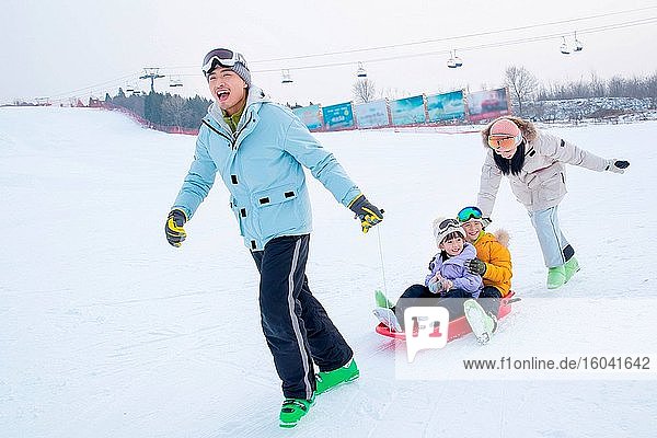 Spielen Schnee Skateboard Glück einer vierköpfigen Familie