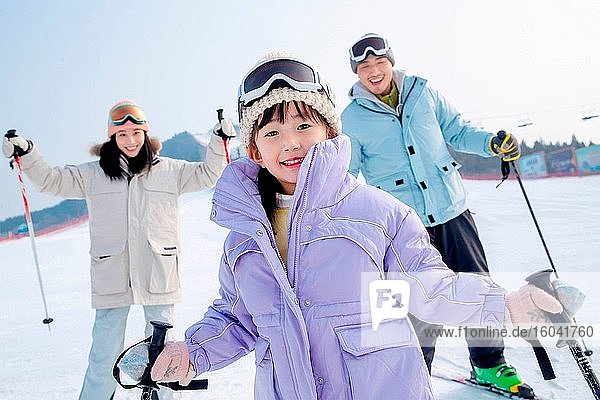 A family of three happy ski ski
