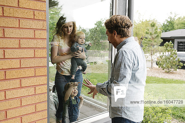 USA  Utah  Salt Lake City  Vater besucht Partner und Kinder (6-11 Monate  2-3) durch Fenster