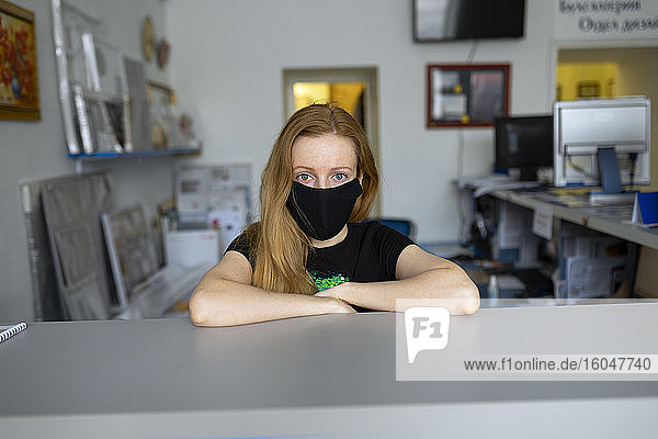 Porträt einer Frau mit Grippemaske im Büro