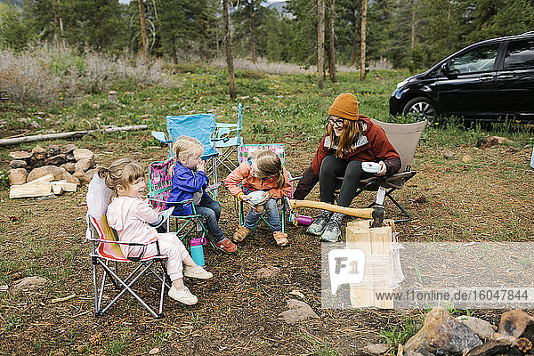 USA  Utah  Uninta Wasatch Cache National Forest  Mother with daughters (2-3  6-7) eating breakfast during camping