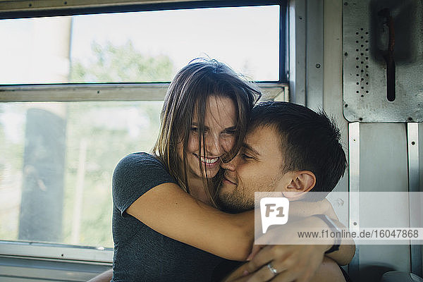 Paar umarmt sich im Zug