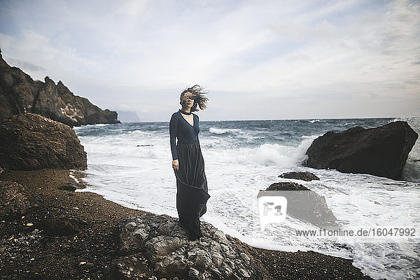 Ukraine  Crimea  Young woman standing on rocky beach