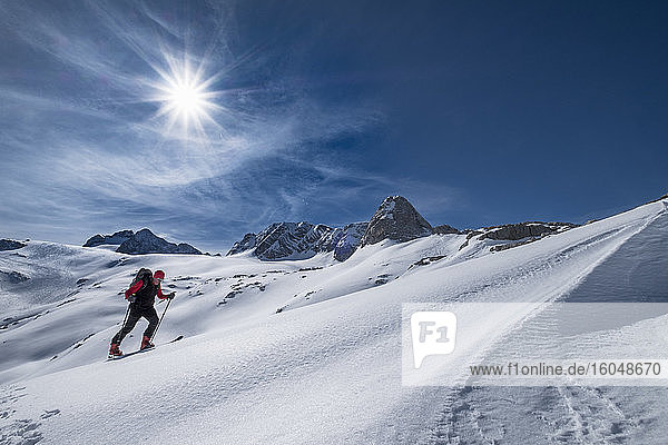 Mann beim Skifahren auf dem schneebedeckten Dachstein gegen den Himmel an einem sonnigen Tag  Österreich