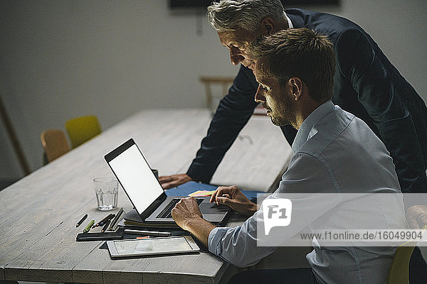 Senior businessman supporting younger colleague in office
